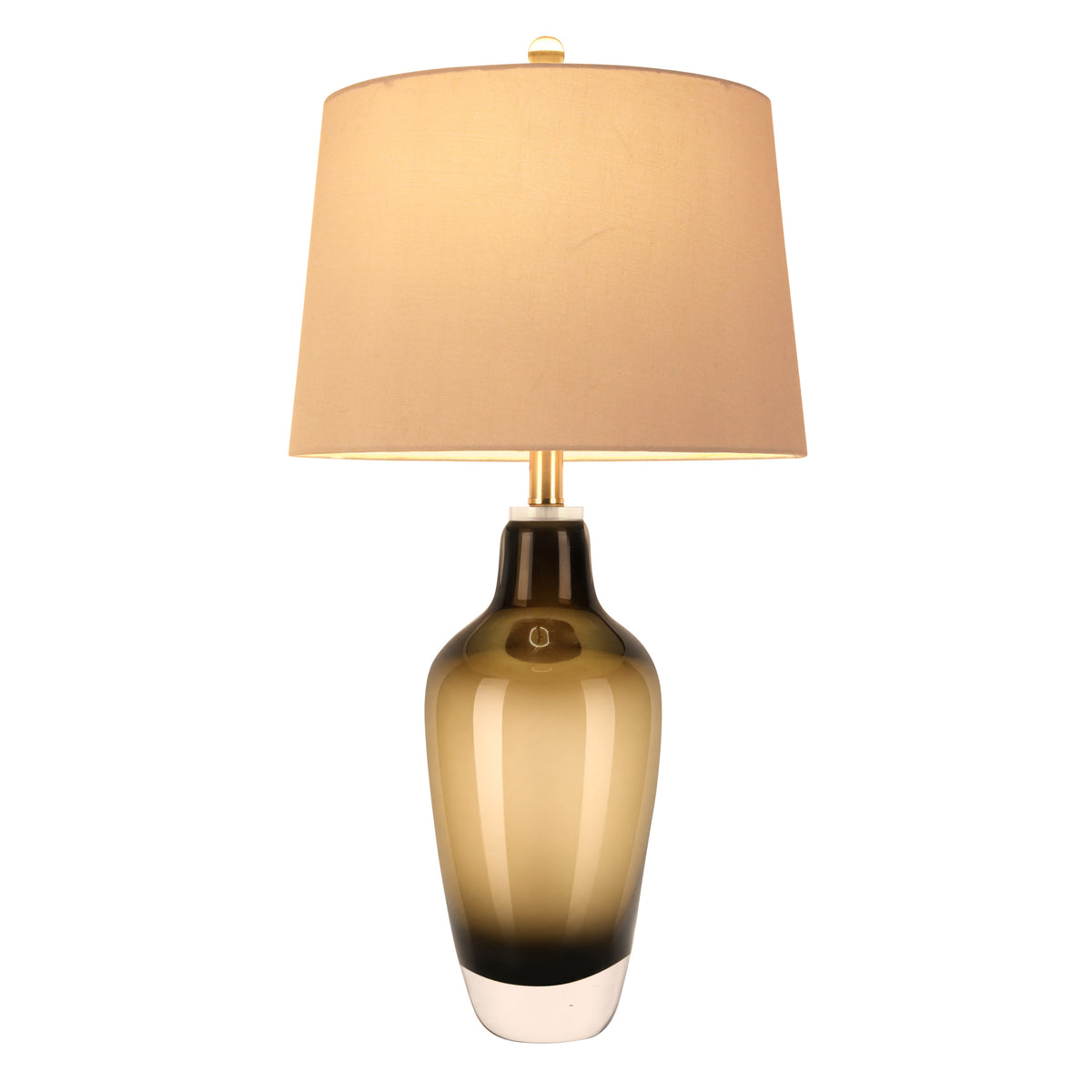 Illuminated art glass table lamp with amber gradient body and warm glowing fabric shade on white background