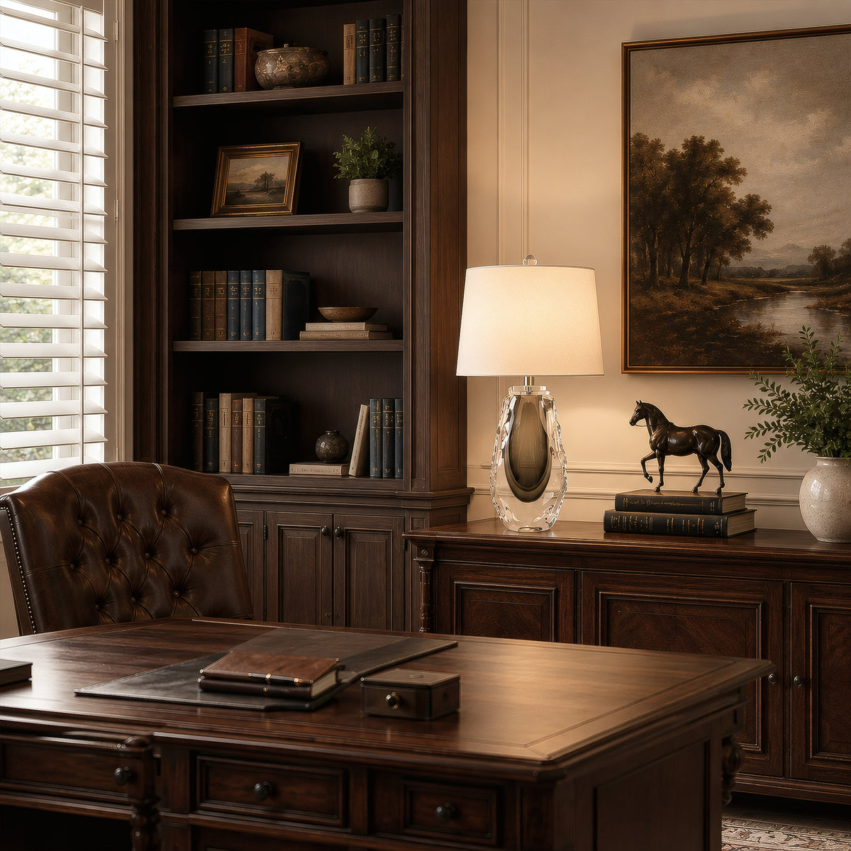 Warmly lit art glass table lamp standing on a dark wooden cabinet in an elegant home library study room.