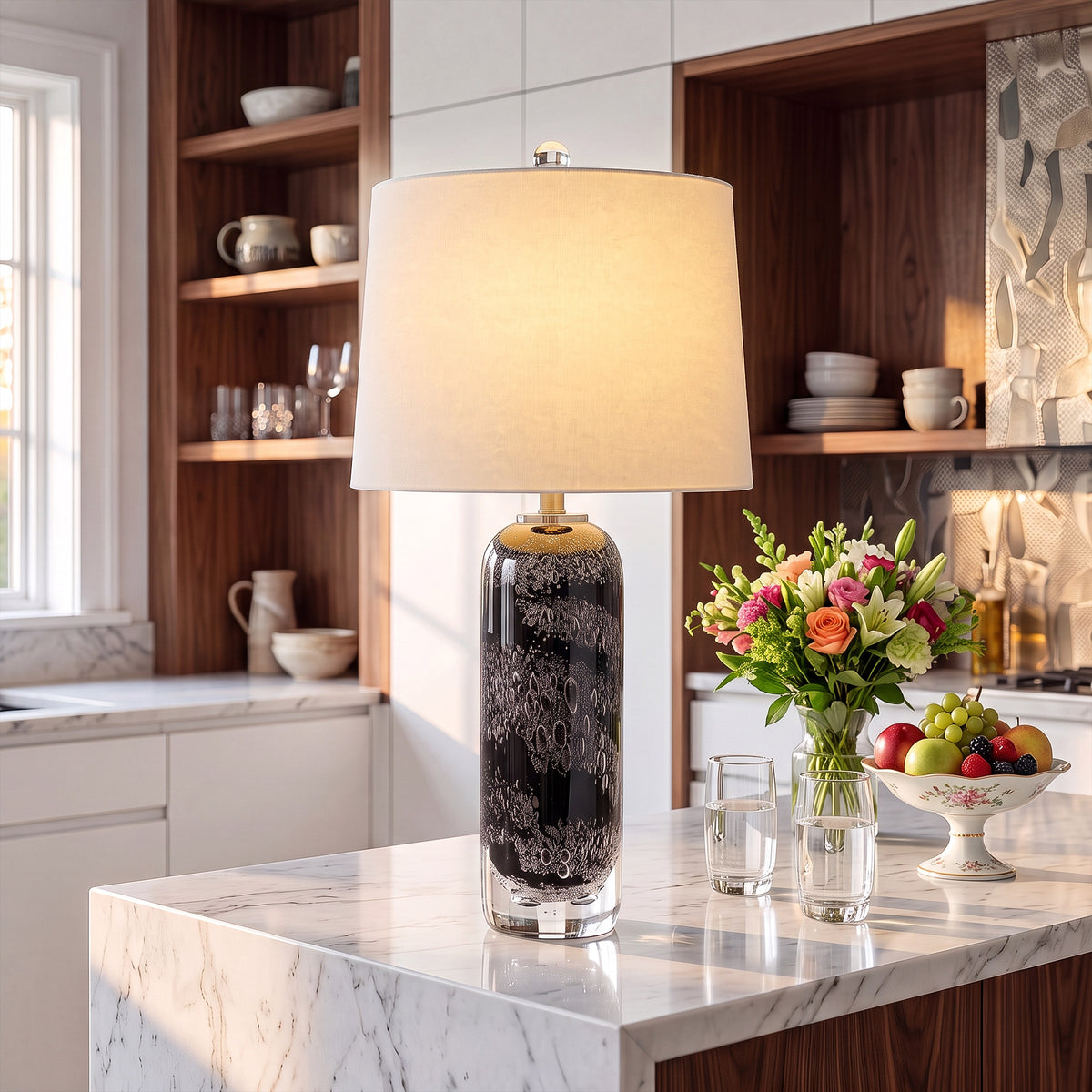 Illuminated art glass table lamp with bubble details on a white marble kitchen island next to fresh flowers.