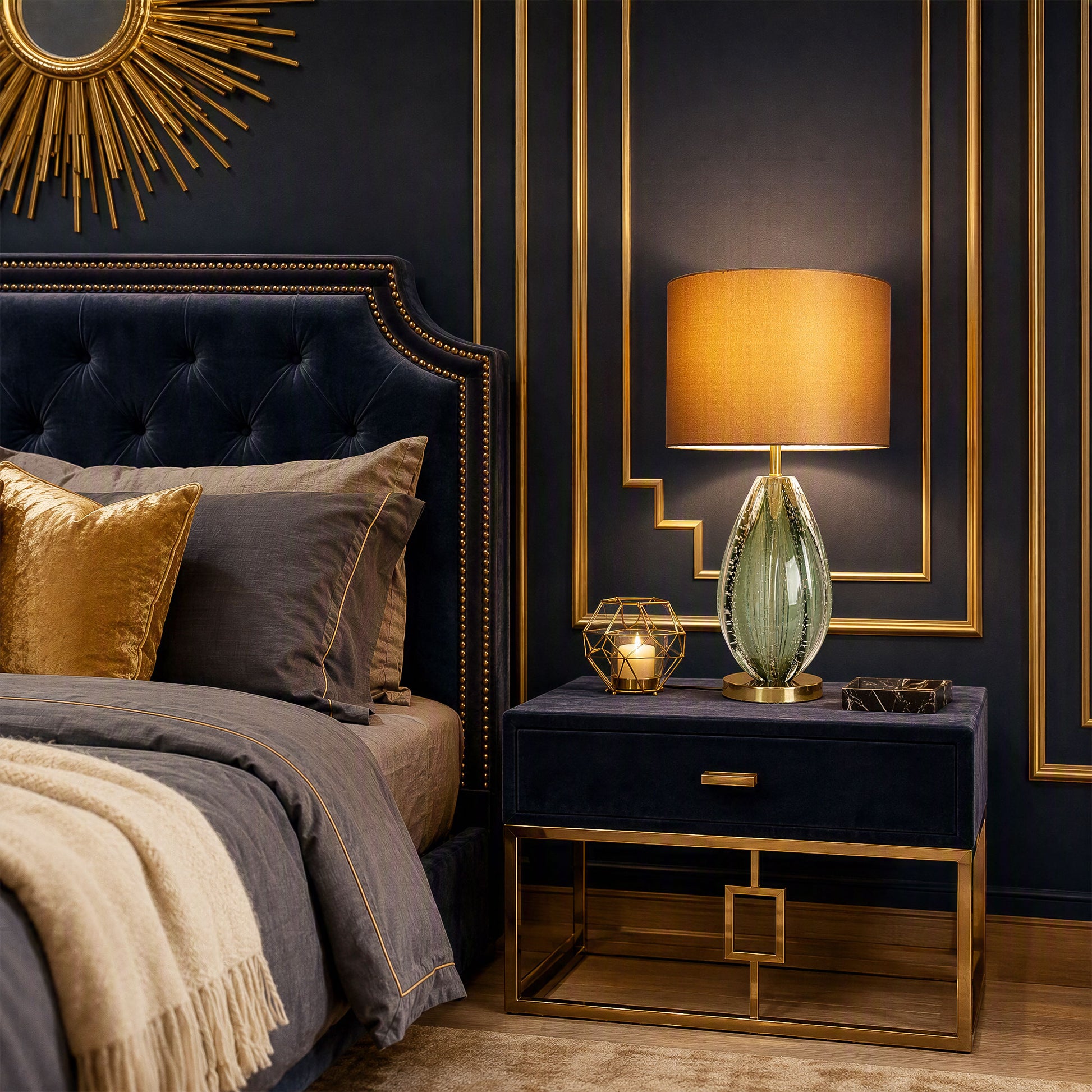 Illuminated art glass table lamp with teardrop teal seeded glass base on navy velvet nightstand in luxury dark bedroom