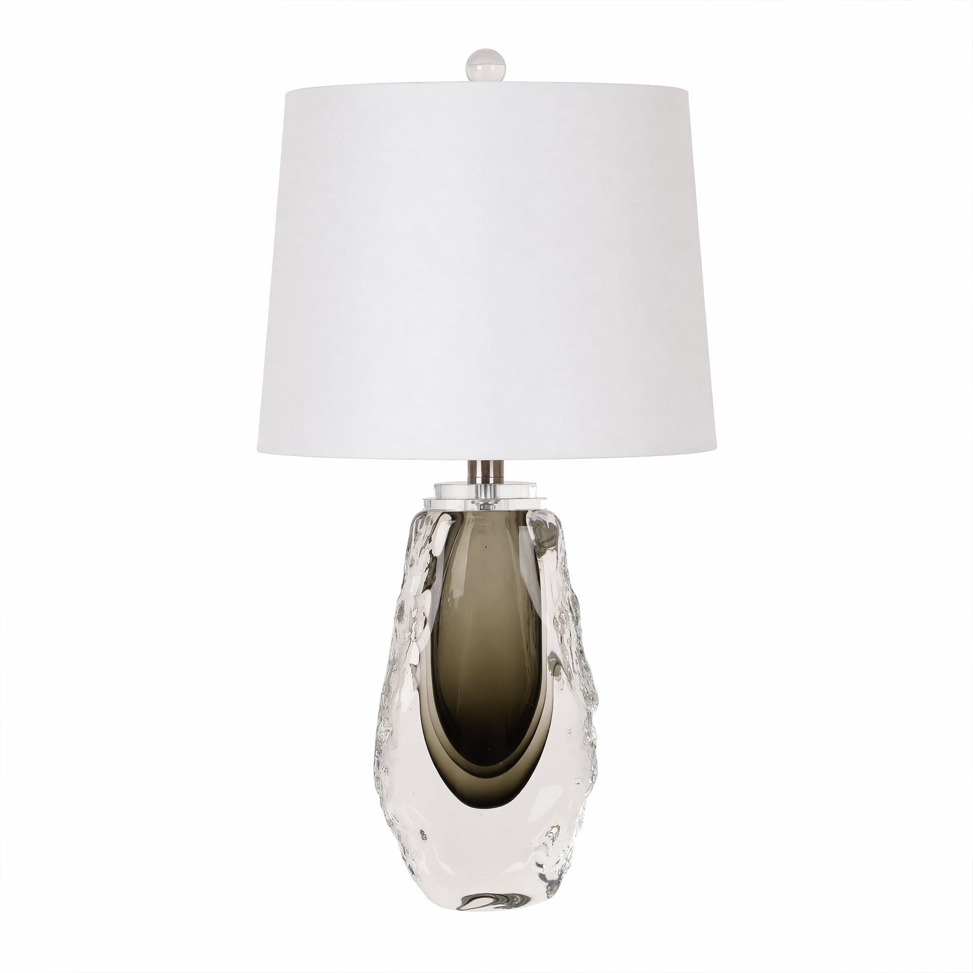Art glass table lamp with clear outer glass and dark smoke green inner core paired with a white fabric shade on a plain background.