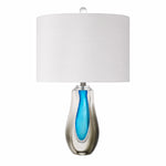 Art glass table lamp with clear smoke outer glass and vibrant blue teardrop inner core on a plain background