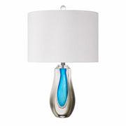 Art glass table lamp with clear smoke outer glass and vibrant blue teardrop inner core on a plain background