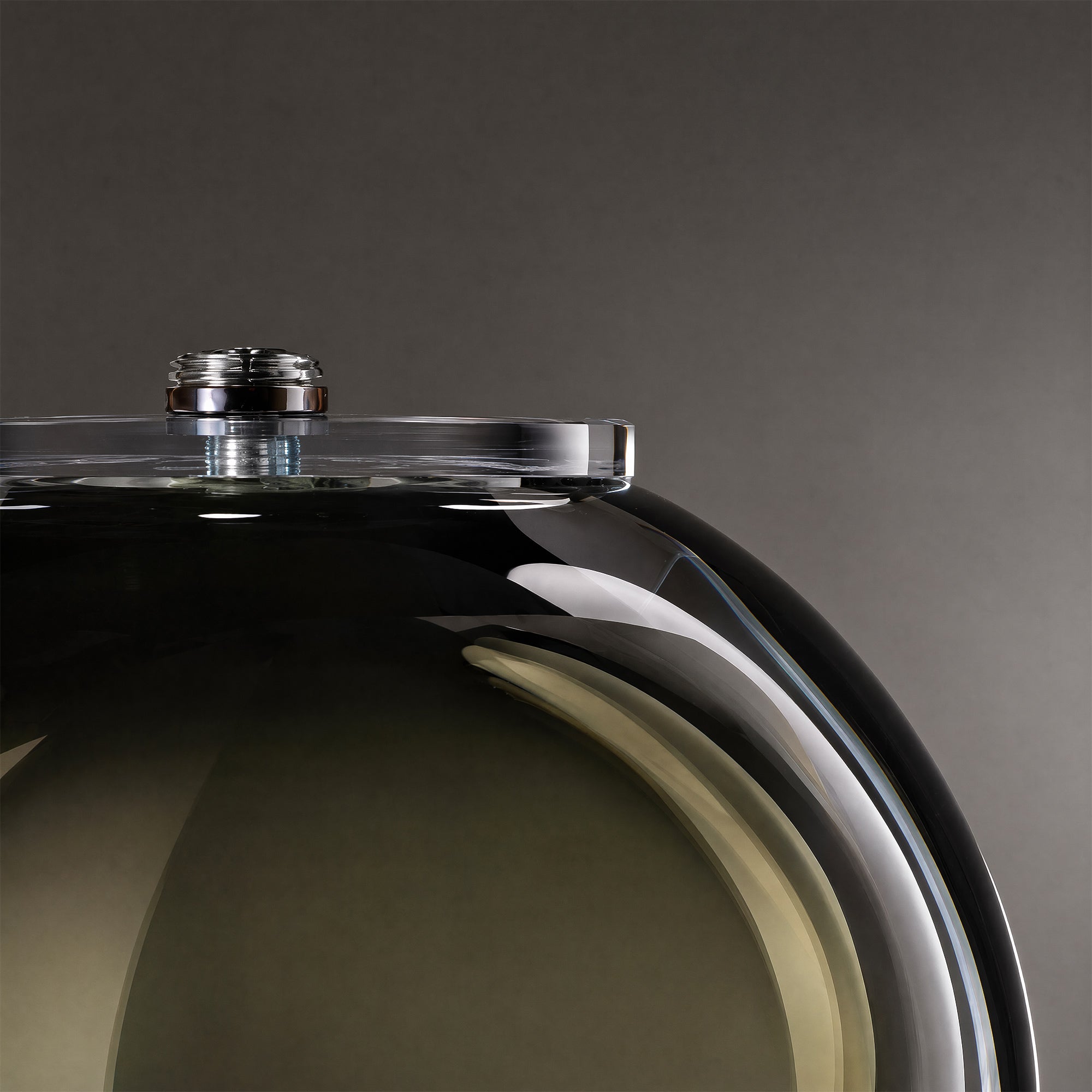Detailed close up of smooth art glass edge and top metal fitting of modern table lamp