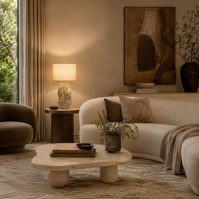 Artistic handmade ceramic table lamp illuminating modern living room on dark wooden side table near sofa