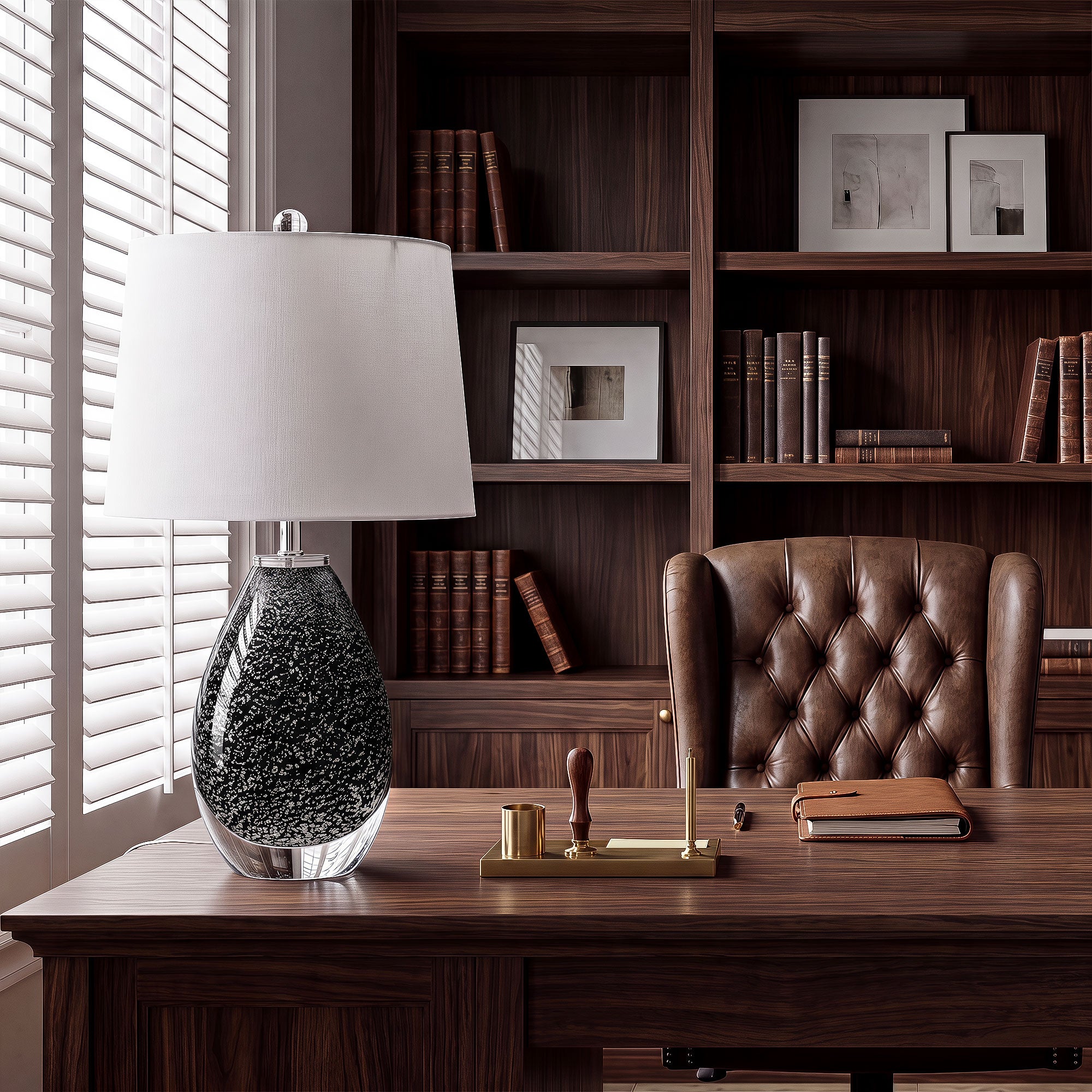 Black glass table lamp with snowflake pattern on dark executive wooden desk in luxury home library.