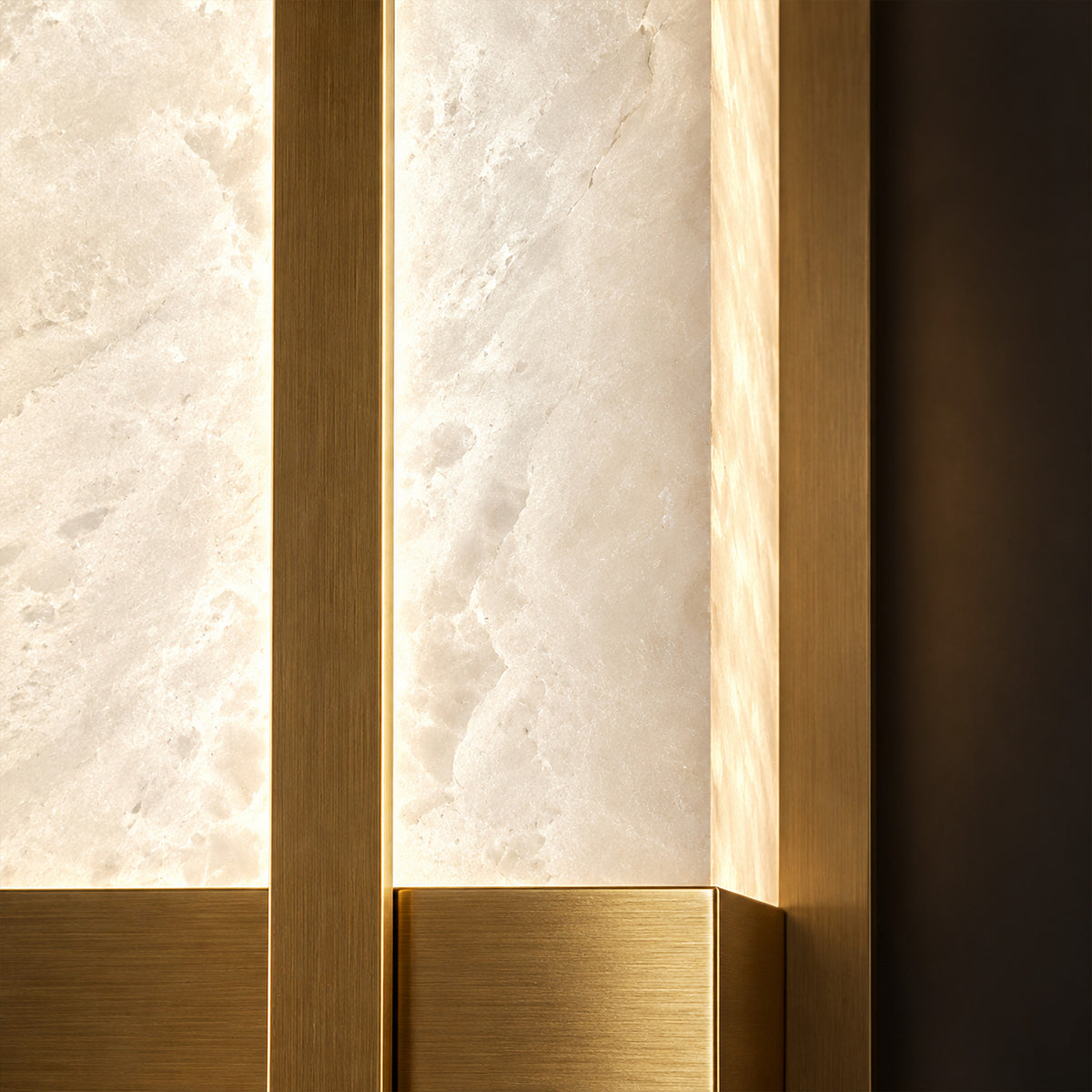 Extreme close up view of brushed solid brass metal trim paired with translucent warm glowing Spanish alabaster stone