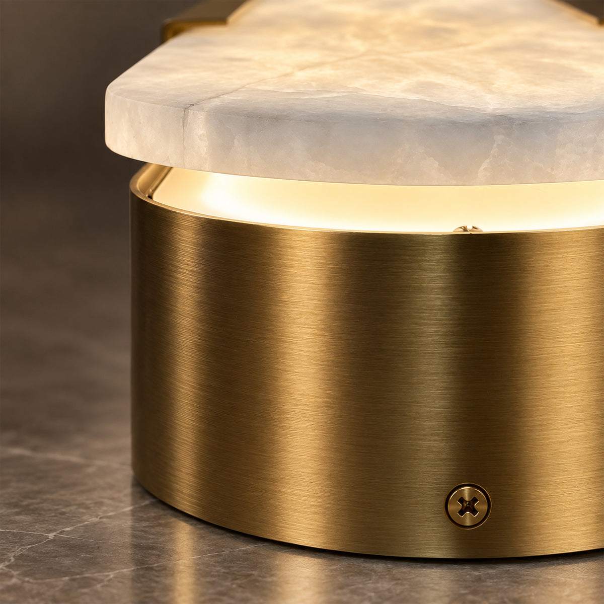 Extreme close up detail of brushed solid brass metal base and thick translucent Spanish alabaster slab