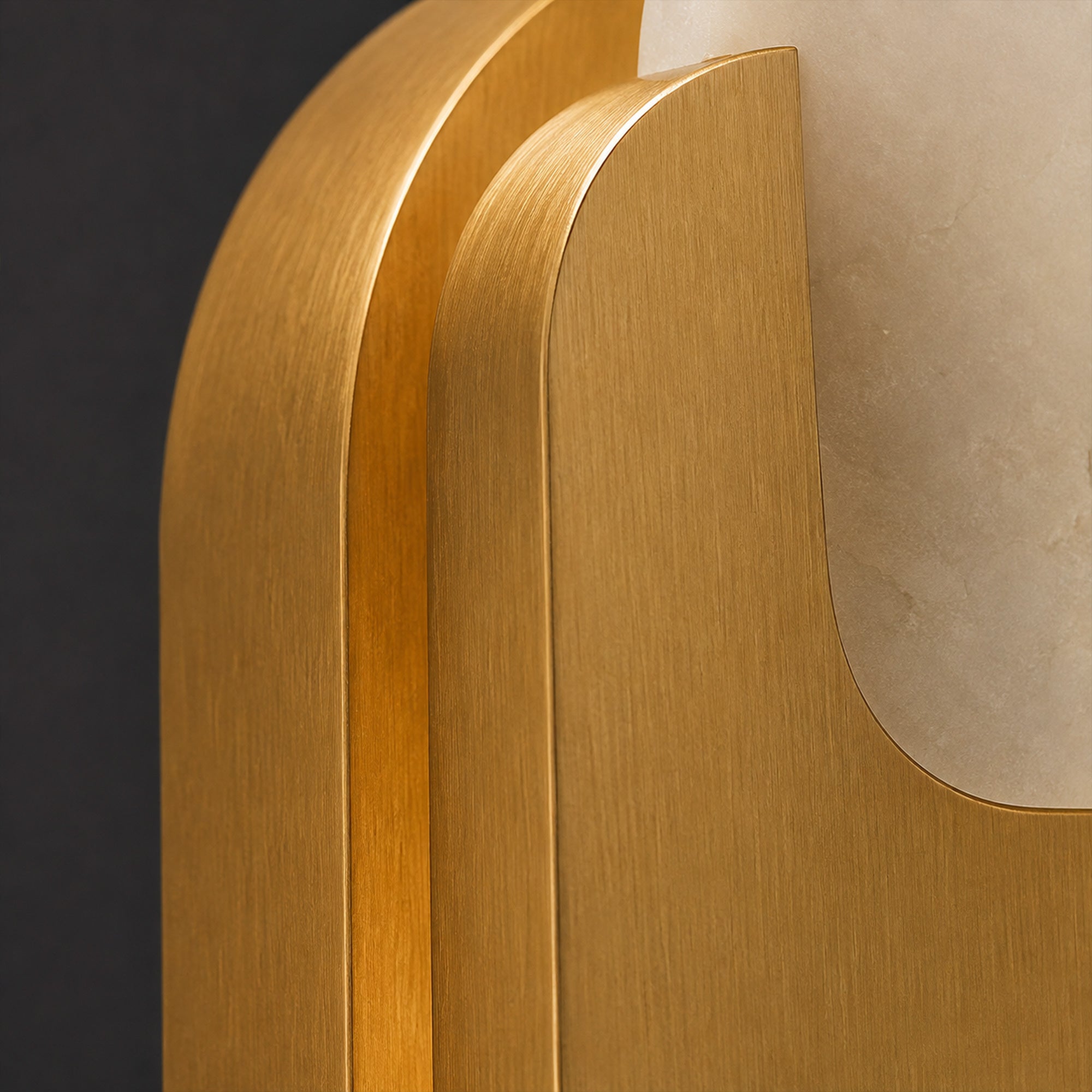 Close up detail showing brushed solid brass hardware finish and smooth rounded corner structure of the wall sconce