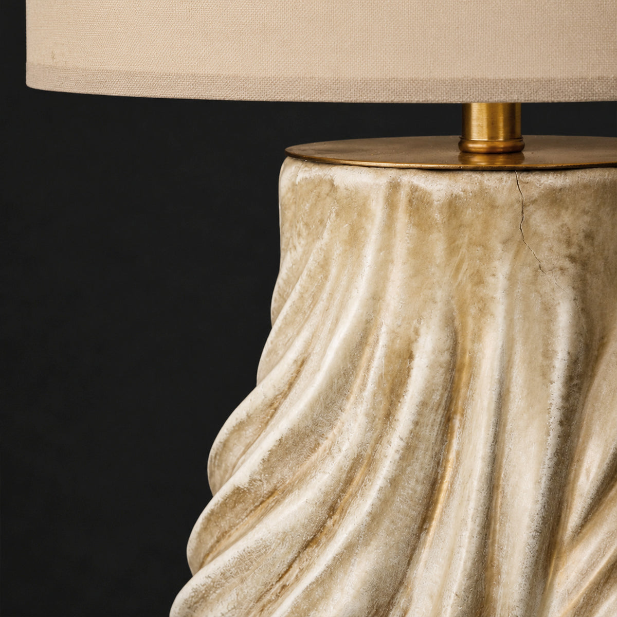 Close up view of brass hardware finish with linen fabric shade and ceramic lamp base
