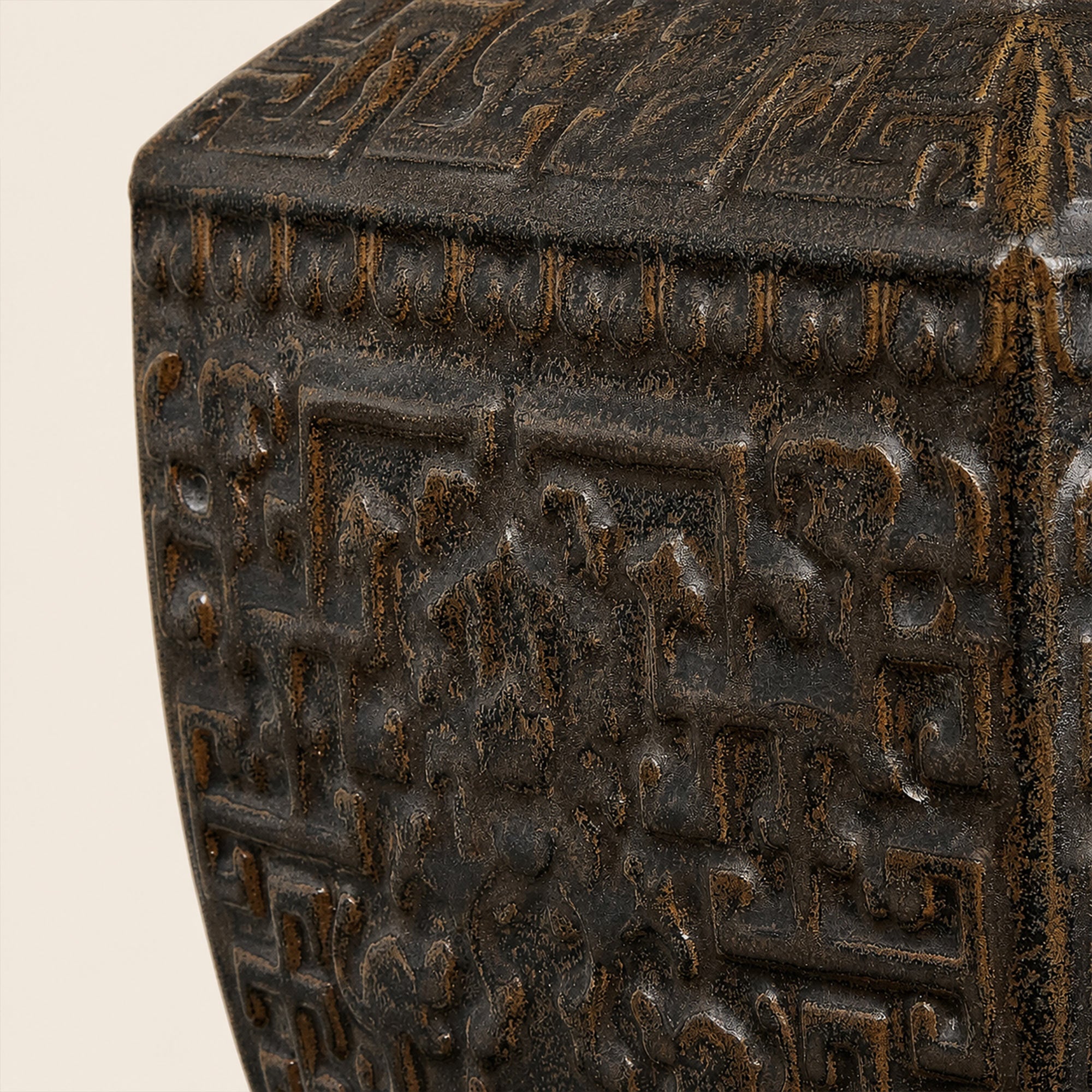Close up detail of dark bronzed ceramic table lamp base showing intricate carved relief texture and antiqued ceramic glaze