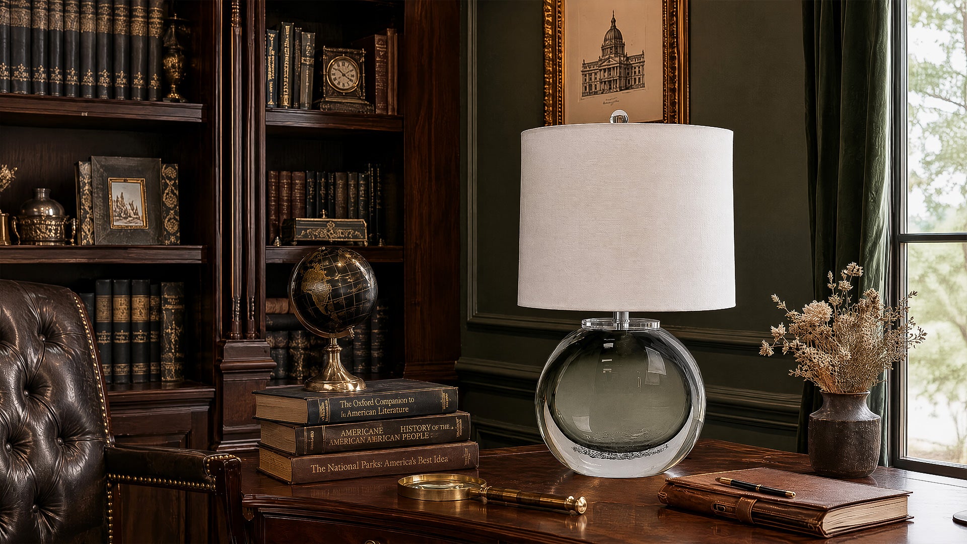 Art glass table lamp on an executive dark wood desk in a vintage home library study room