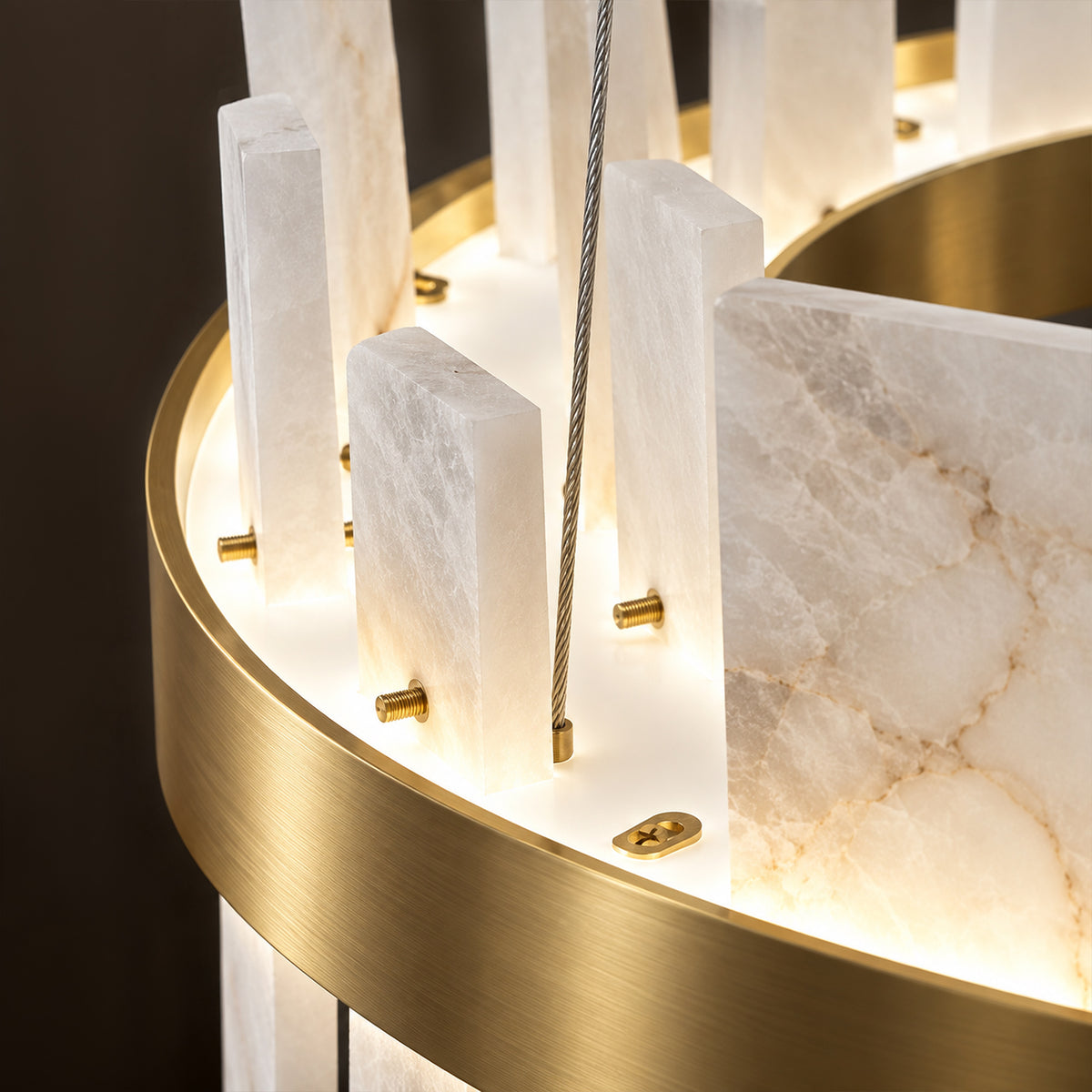 Close up view of natural vein alabaster slabs mounted with brass screws on brushed brass ring structure
