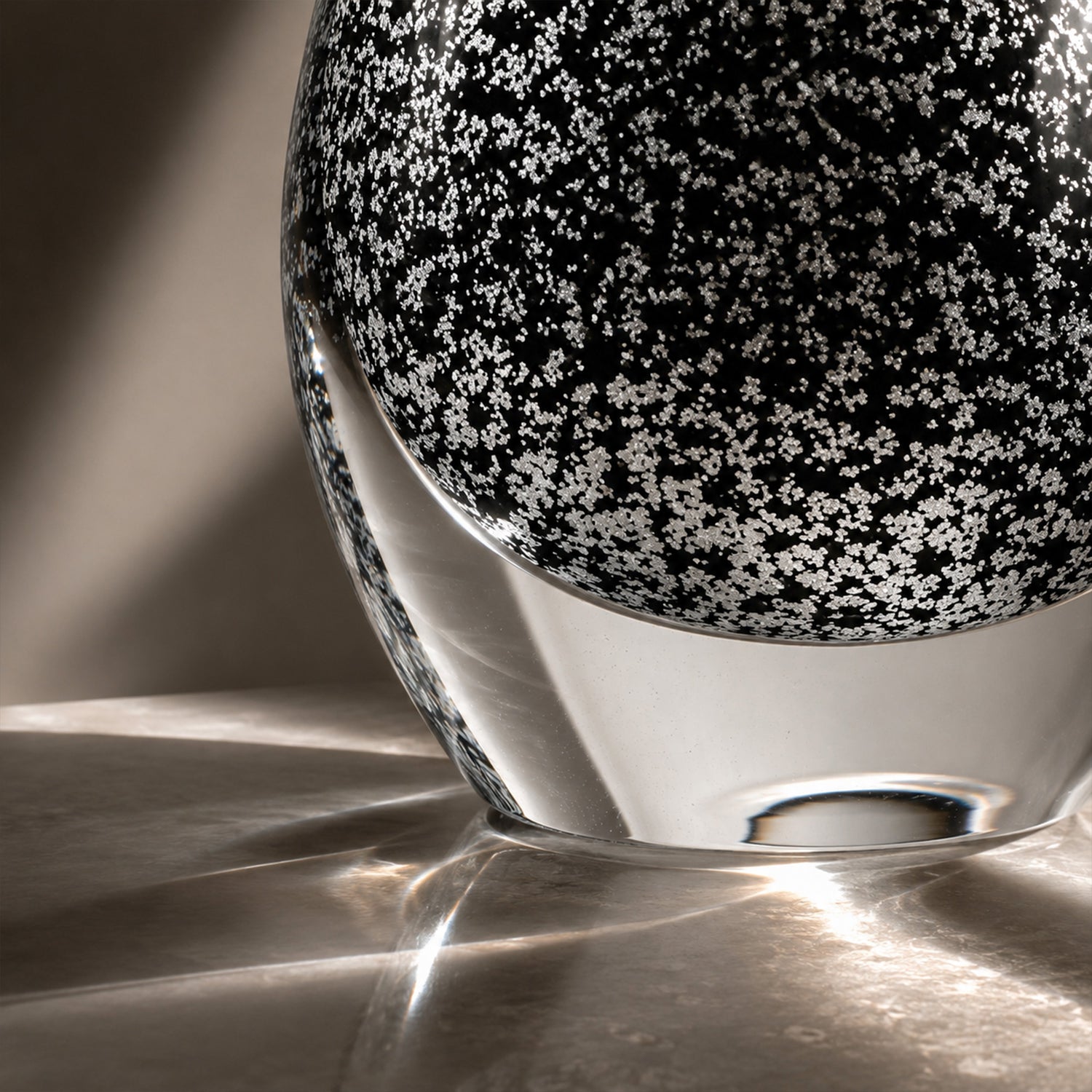Close up view of clear thick glass base showing intricate snowflake bubble texture and beautiful light refraction.