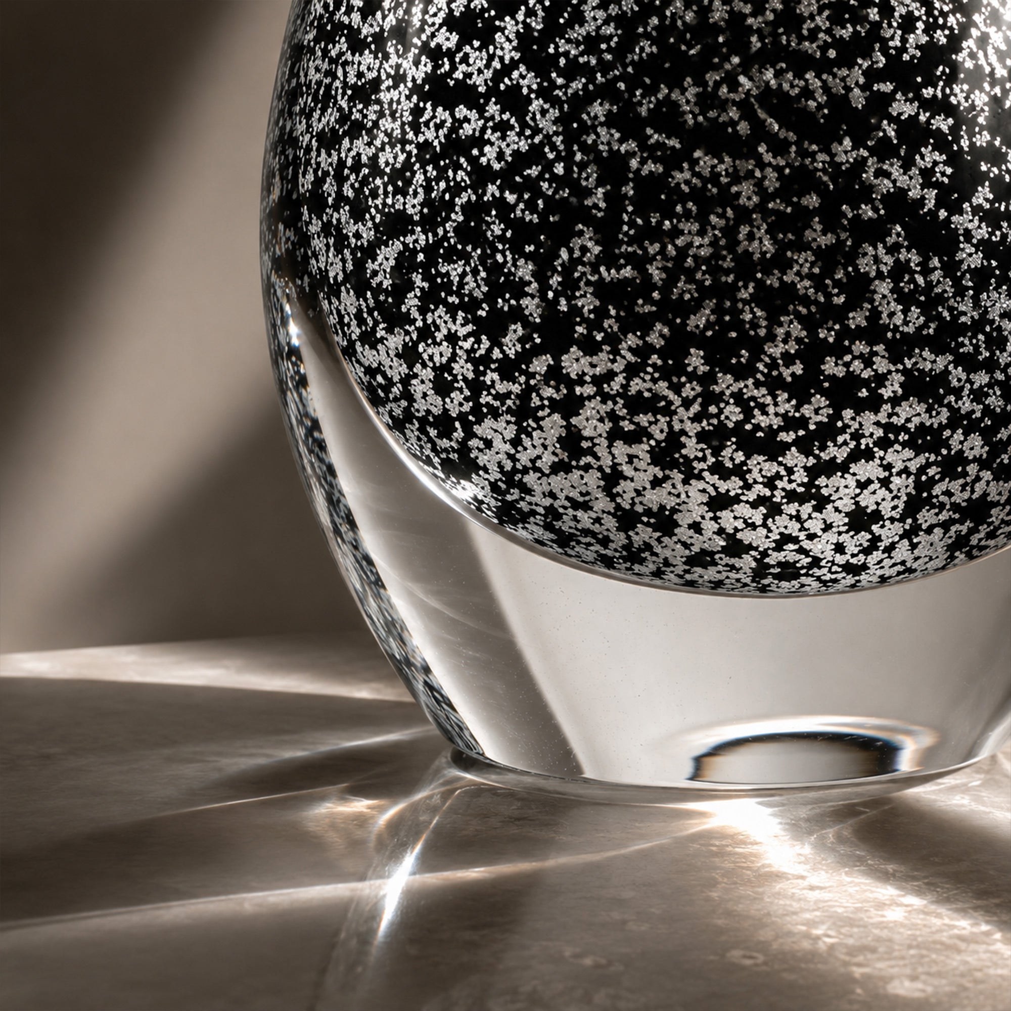 Close up view of clear thick glass base showing intricate snowflake bubble texture and beautiful light refraction.
