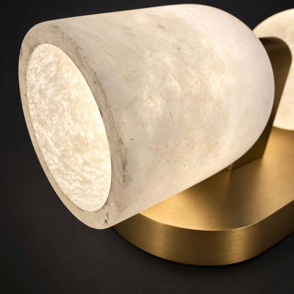 Close up view of illuminated thick Spanish natural alabaster shade showing internal texture and brushed solid brass mounting structure