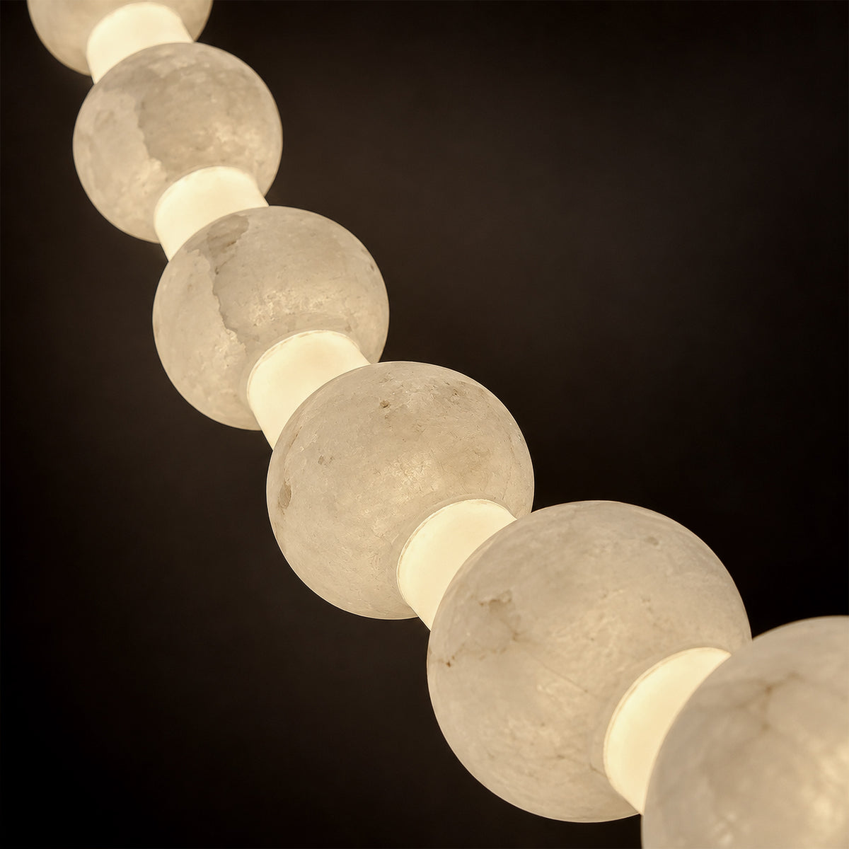 Close up view of translucent Spanish alabaster spheres showing delicate cloud veins and soft warm light glow
