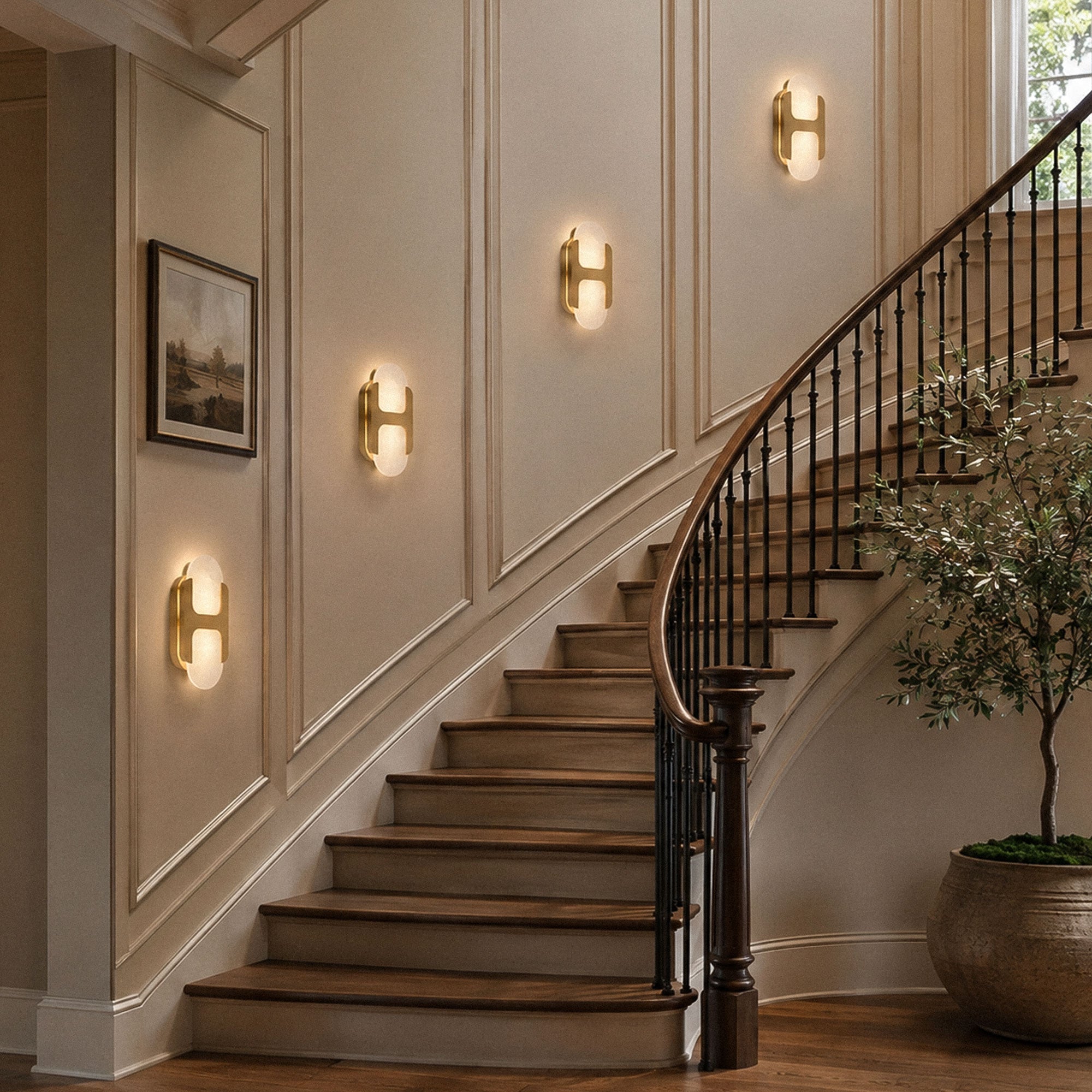 Multiple illuminated brass alabaster wall sconces mounted on a grand curved staircase wall creating warm lighting ambiance