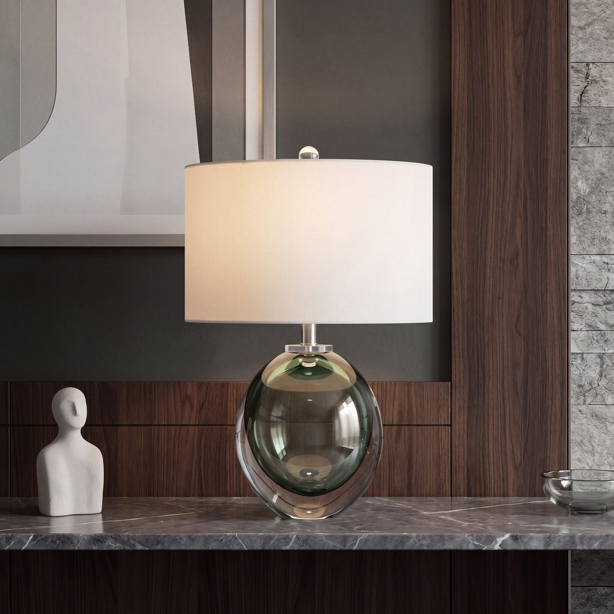Dark green bubble glass table lamp with warm glow on a marble console table in a stylish entryway.