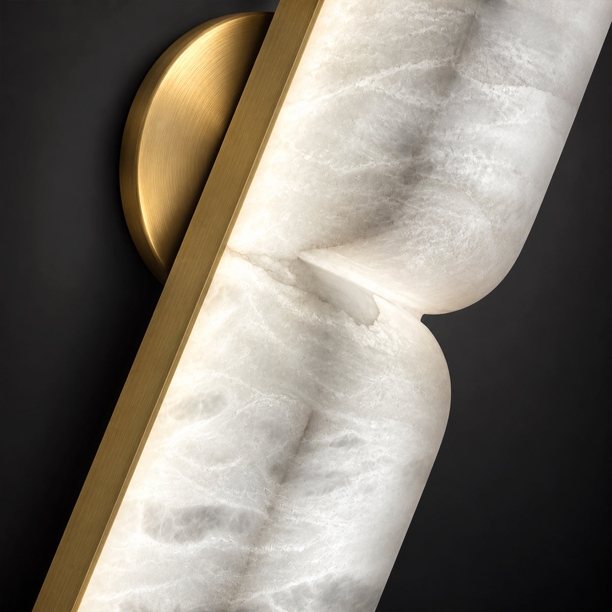 Macro shot of B shaped sculpted curved natural alabaster stone paired with brushed gold brass metal fitting