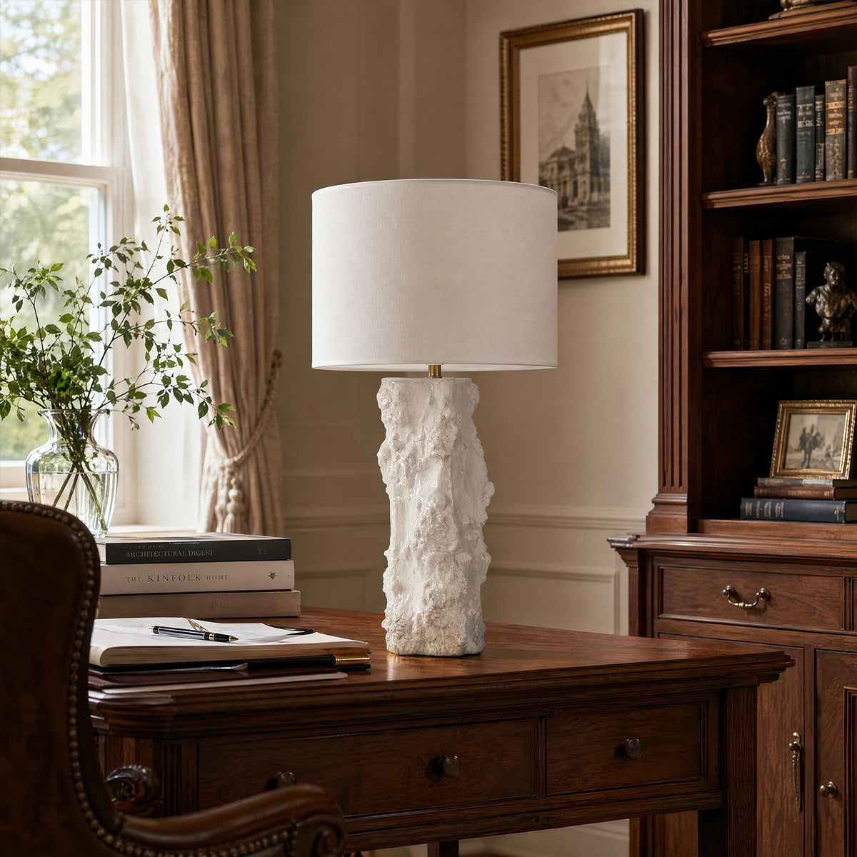 Handmade textured ceramic vessel table lamp turned off on wooden executive desk in classic home office study