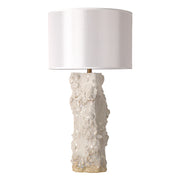 Handmade vintage organic textured ceramic vessel table lamp with white drum shade turned off on white background