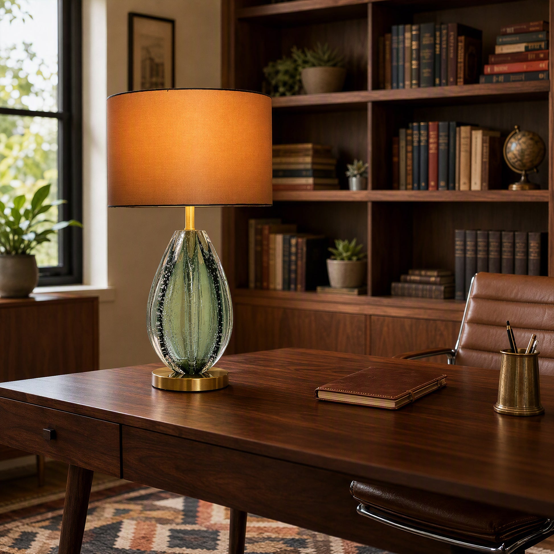 Illuminated teal seeded glass table lamp on executive dark wood desk in sophisticated home office study with bookcase