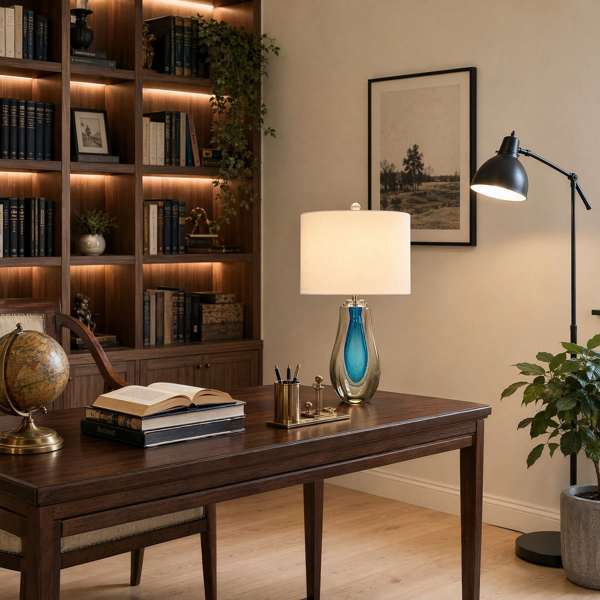 Art glass table lamp emitting warm light on a rich dark wood desk in an elegant home office