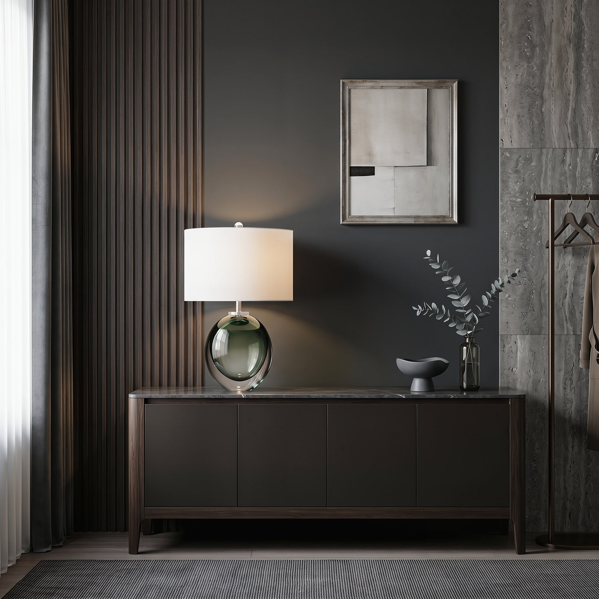 Illuminated dark green art glass table lamp casting soft glow on a long wooden console table in modern foyer.