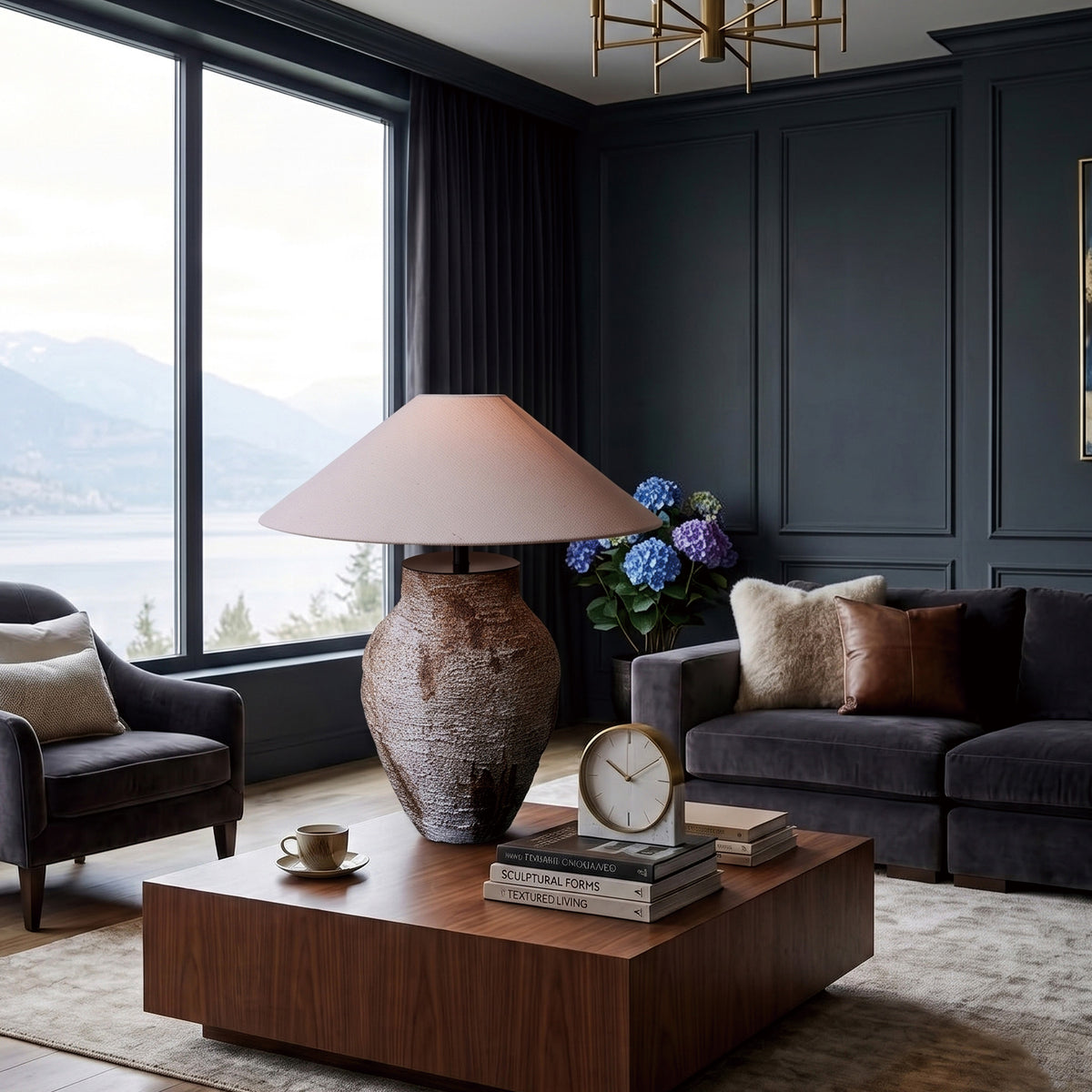 Illuminated rustic ceramic table lamp creating warm ambience on a wooden coffee table in a modern dark living room.