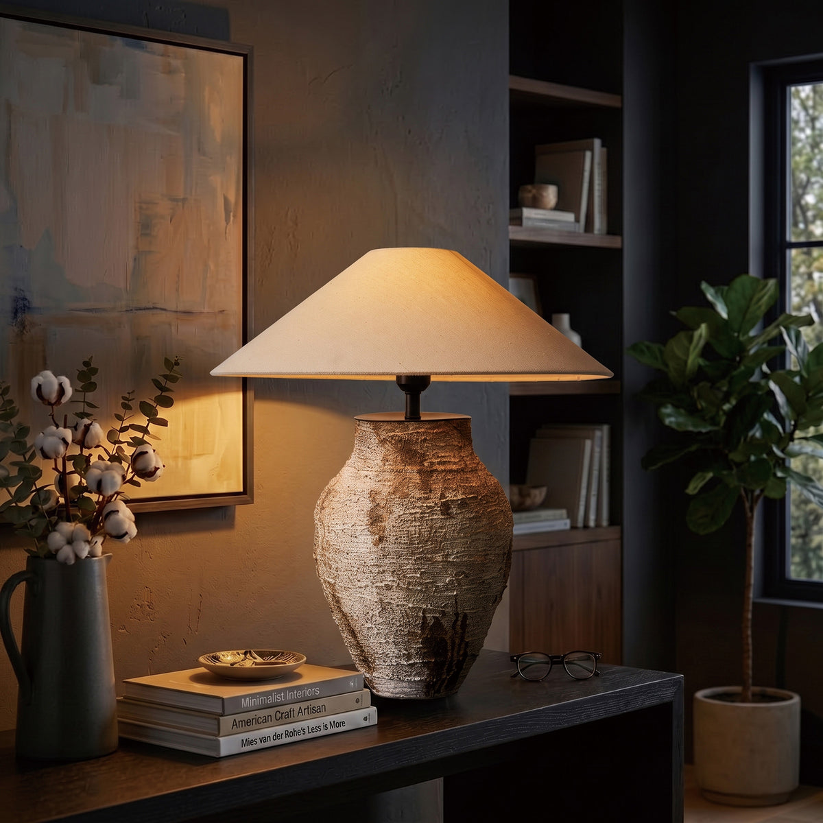 Illuminated vintage white ceramic table lamp casting a cozy glow on a dark entryway console table.