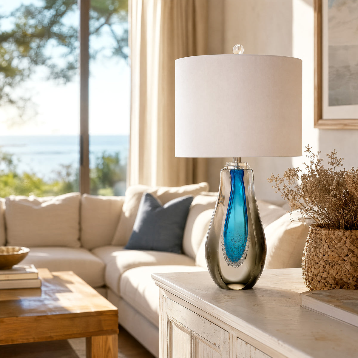 Warm lit art glass table lamp placed on a dark wood end table next to a sofa in a modern living room