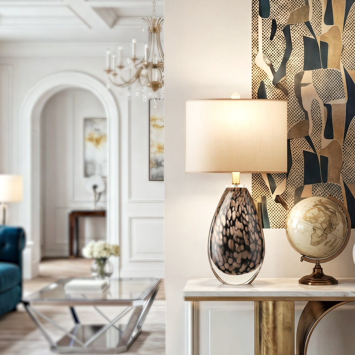 A bright modern classic hallway entryway displaying a luxury hand blown glass lamp next to a vintage globe on a white marble console table with an abstract art backdrop.