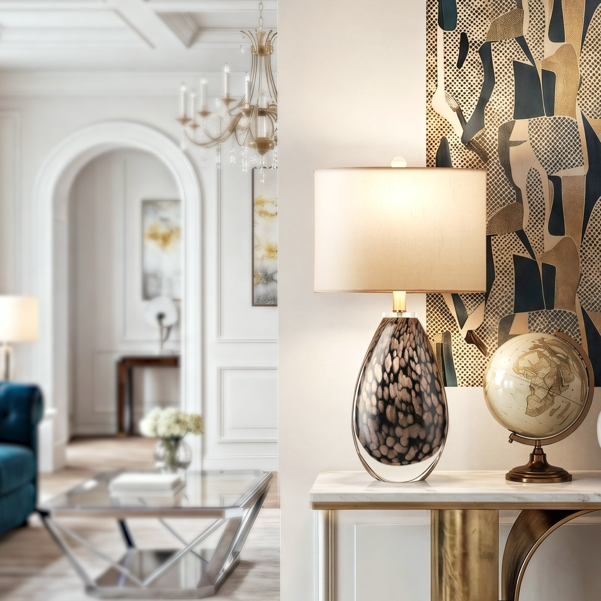 A bright modern classic hallway entryway displaying a luxury hand blown glass lamp next to a vintage globe on a white marble console table with an abstract art backdrop.