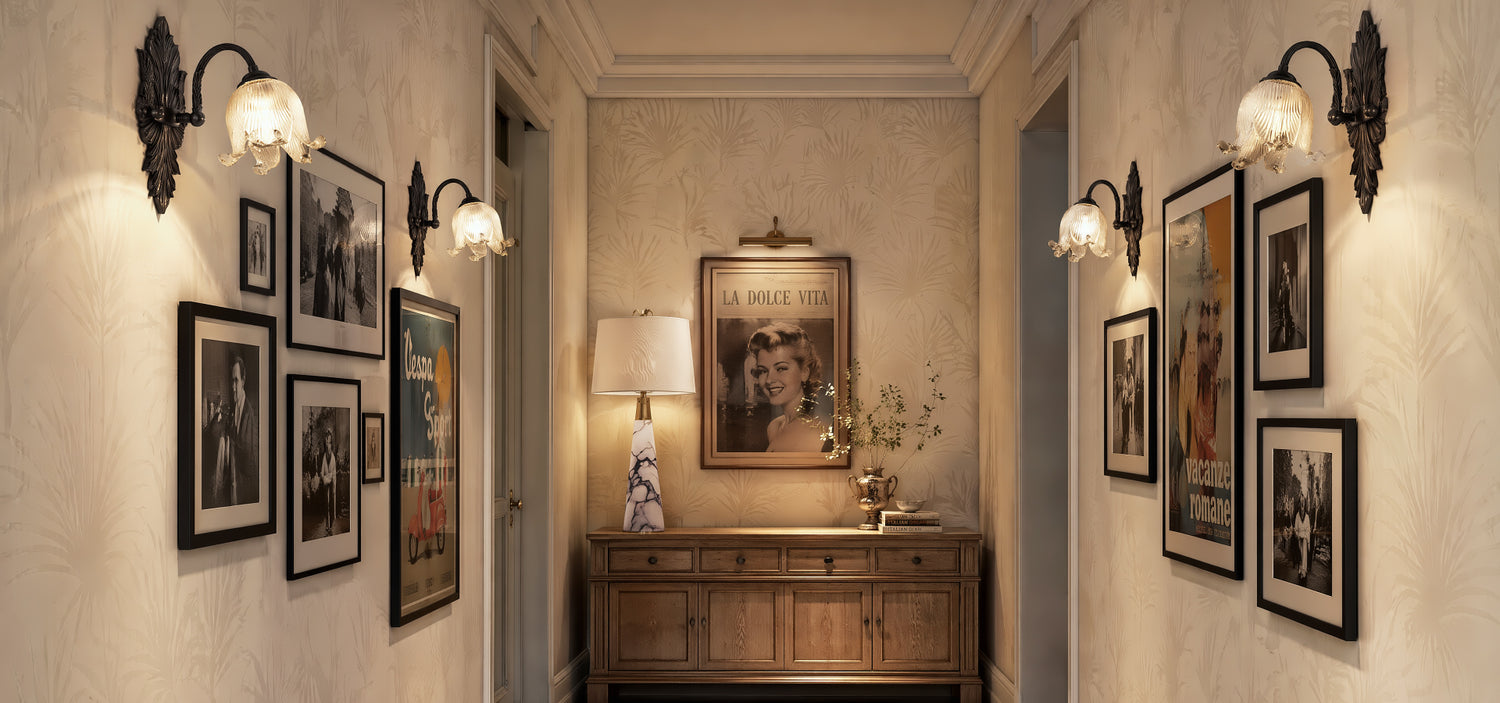 A gallery-style entryway with a translucent organic alabaster table lamp on a wooden credenza, highlighting mid-century modern home decor and retro art pieces.