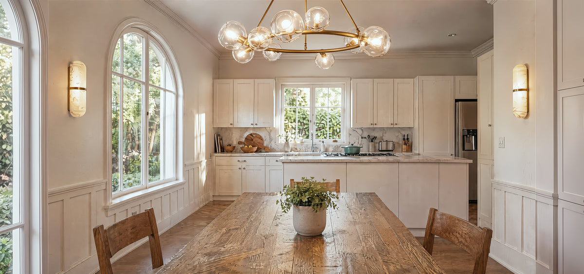 A serene, sunlit mid-century modern dining room showcasing a sculptural brushed brass chandelier and wall-mounted alabaster sconces with beautiful natural cloud-like veining under soft daylight.