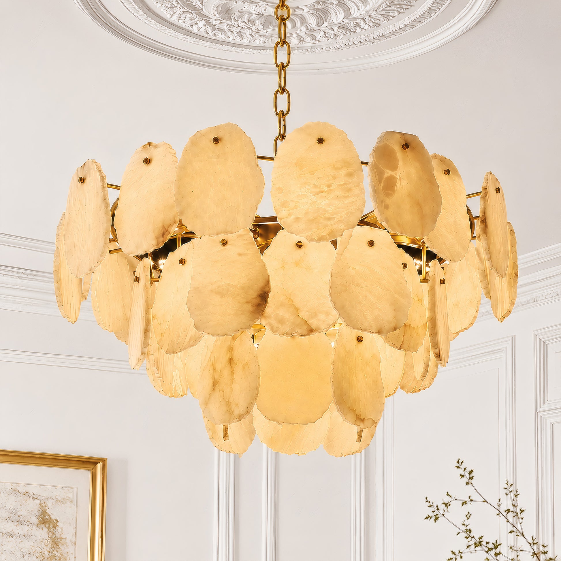 Detailed view of a round three-tier Spanish alabaster chandelier mounted on a decorative plaster medallion in a bright white modern organic interior.