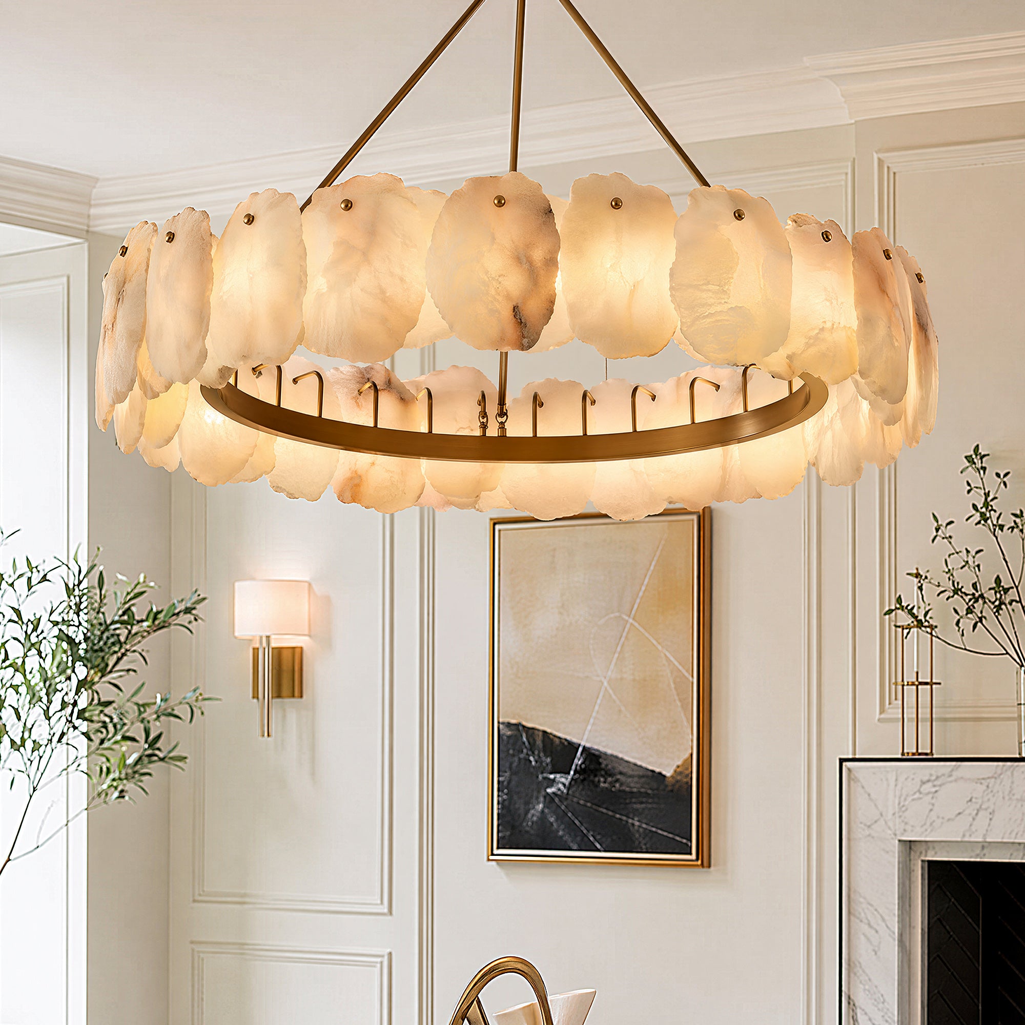 A close up view of a round Spanish alabaster stone slab chandelier lit during the day inside a sophisticated cream toned living room with a white marble fireplace.