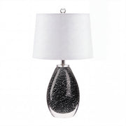 Murano style teardrop black glass table lamp with snowflake seeded pattern turned off on white background.