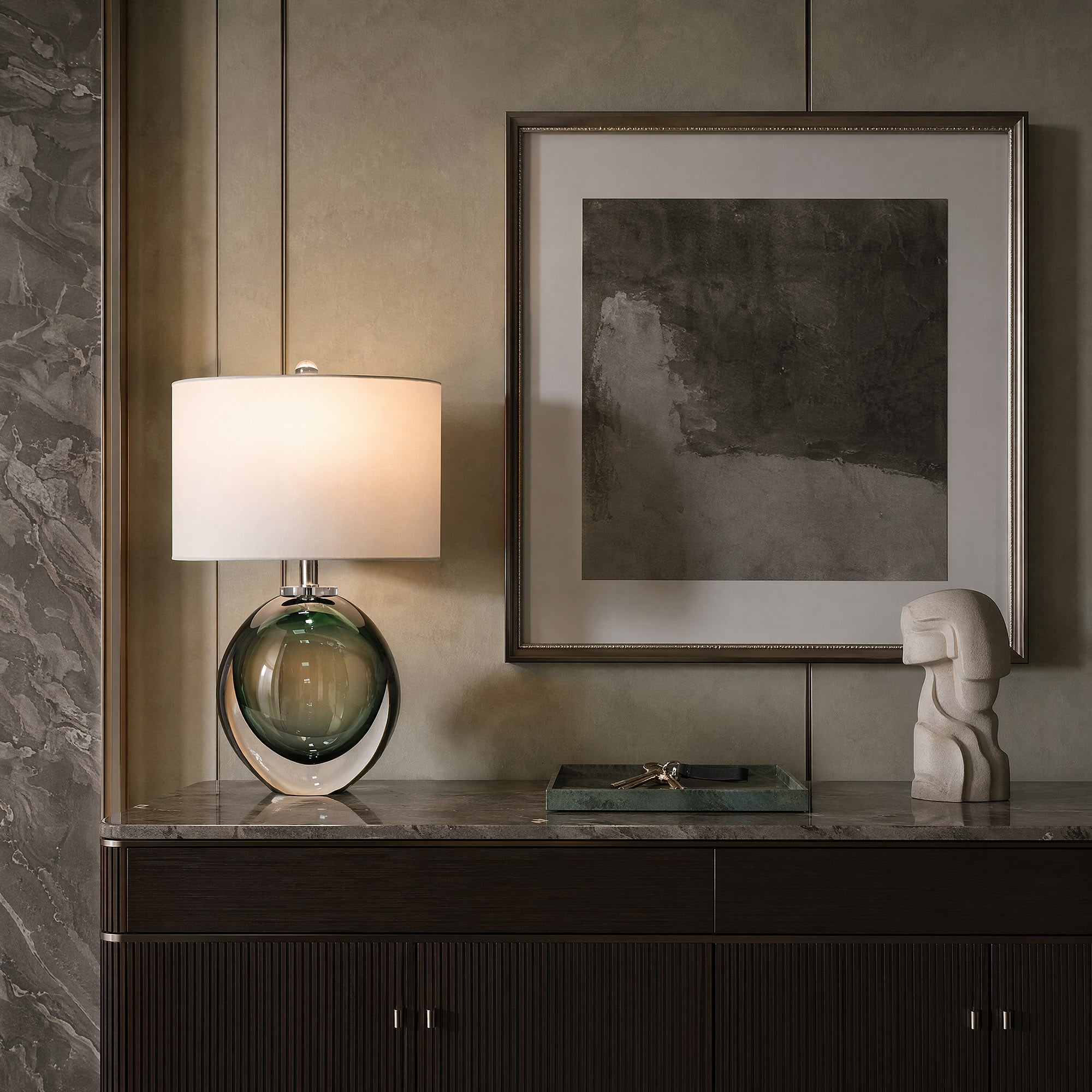 Murano style green bubble glass table lamp placed on a marble top credenza in elegant modern living room.
