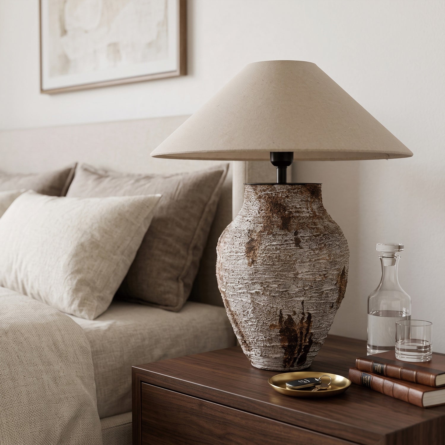 Rustic textured white ceramic table lamp turned off on a dark wood nightstand beside a cozy bed.