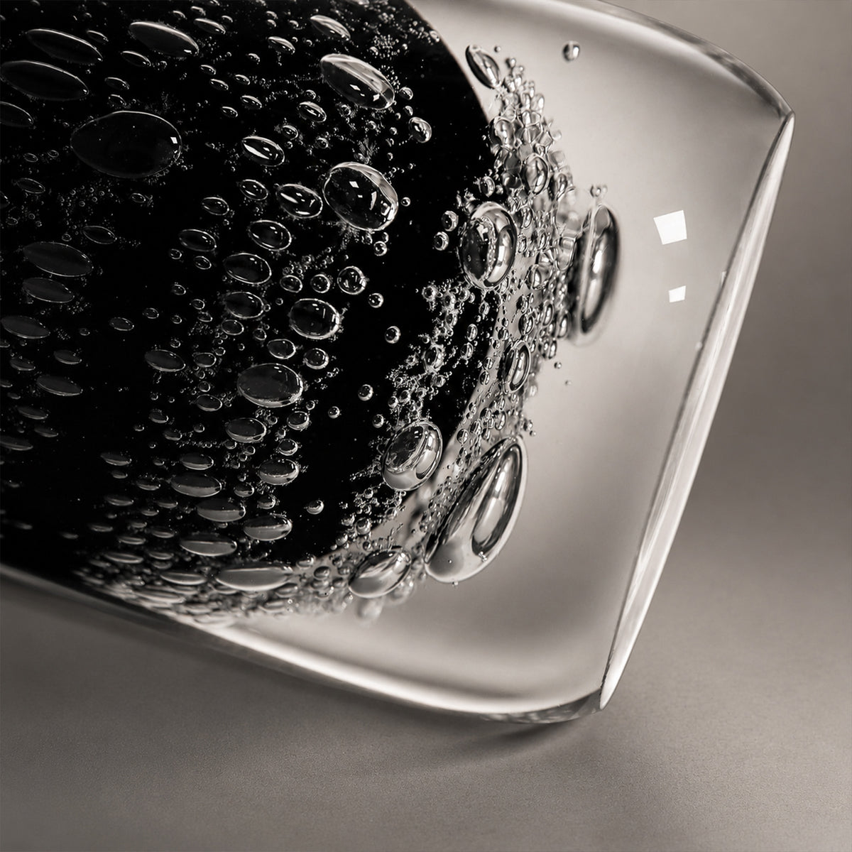 Extreme close up view showing detailed inner bubbles and clear outer glass layer of the table lamp base.
