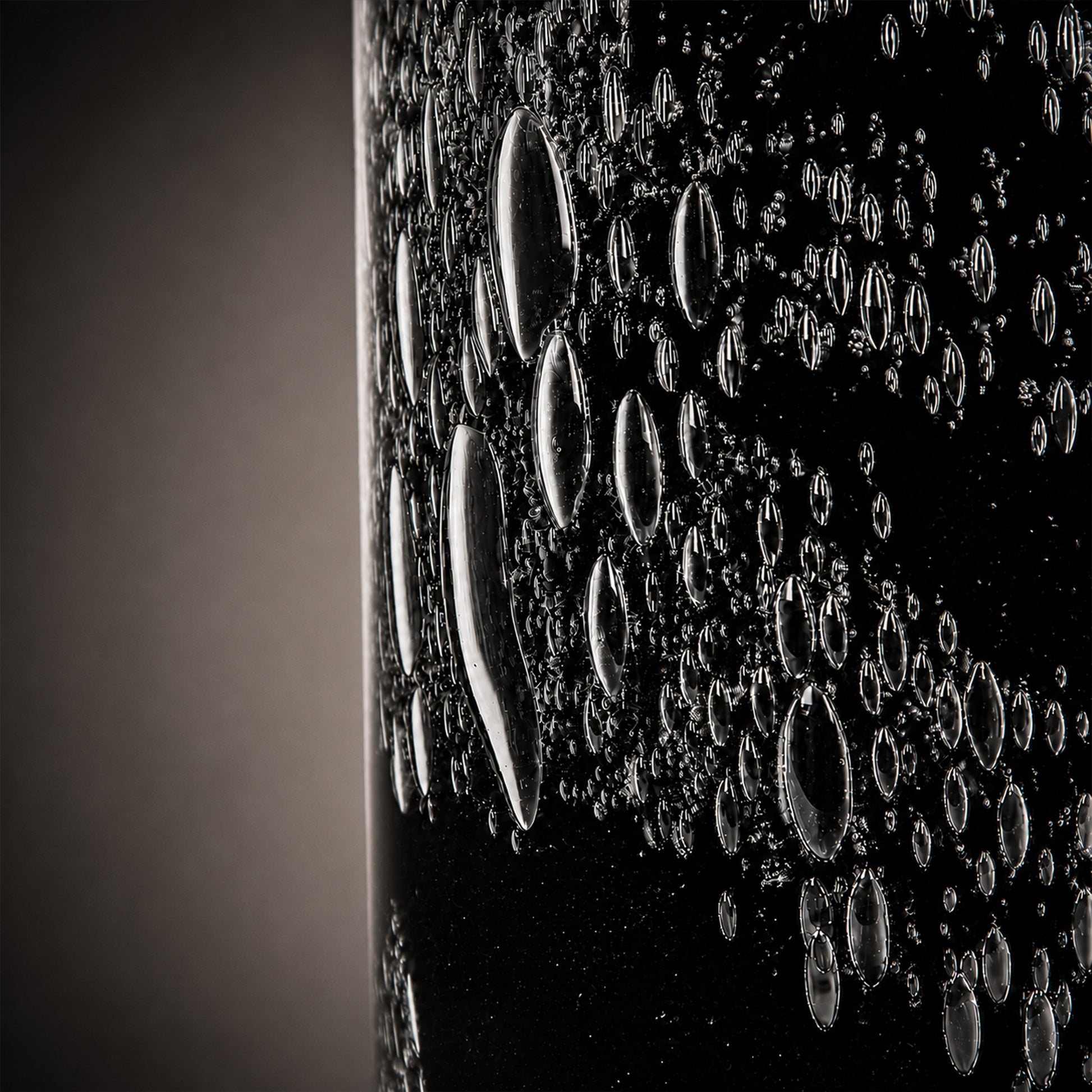 Macro macro detailed photograph of rich bubble pattern textures embedded within black art glass.