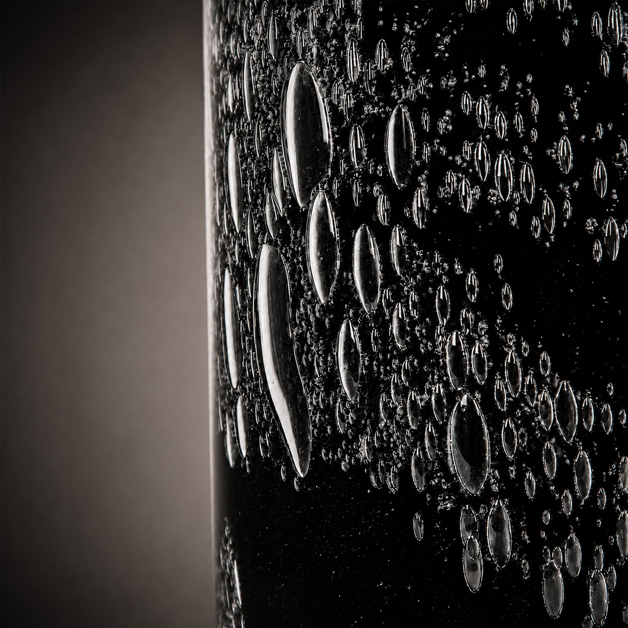 Macro macro detailed photograph of rich bubble pattern textures embedded within black art glass.