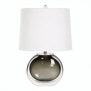 Smoke gray art glass table lamp with clear outer glass layer and white drum shade turned off on white background