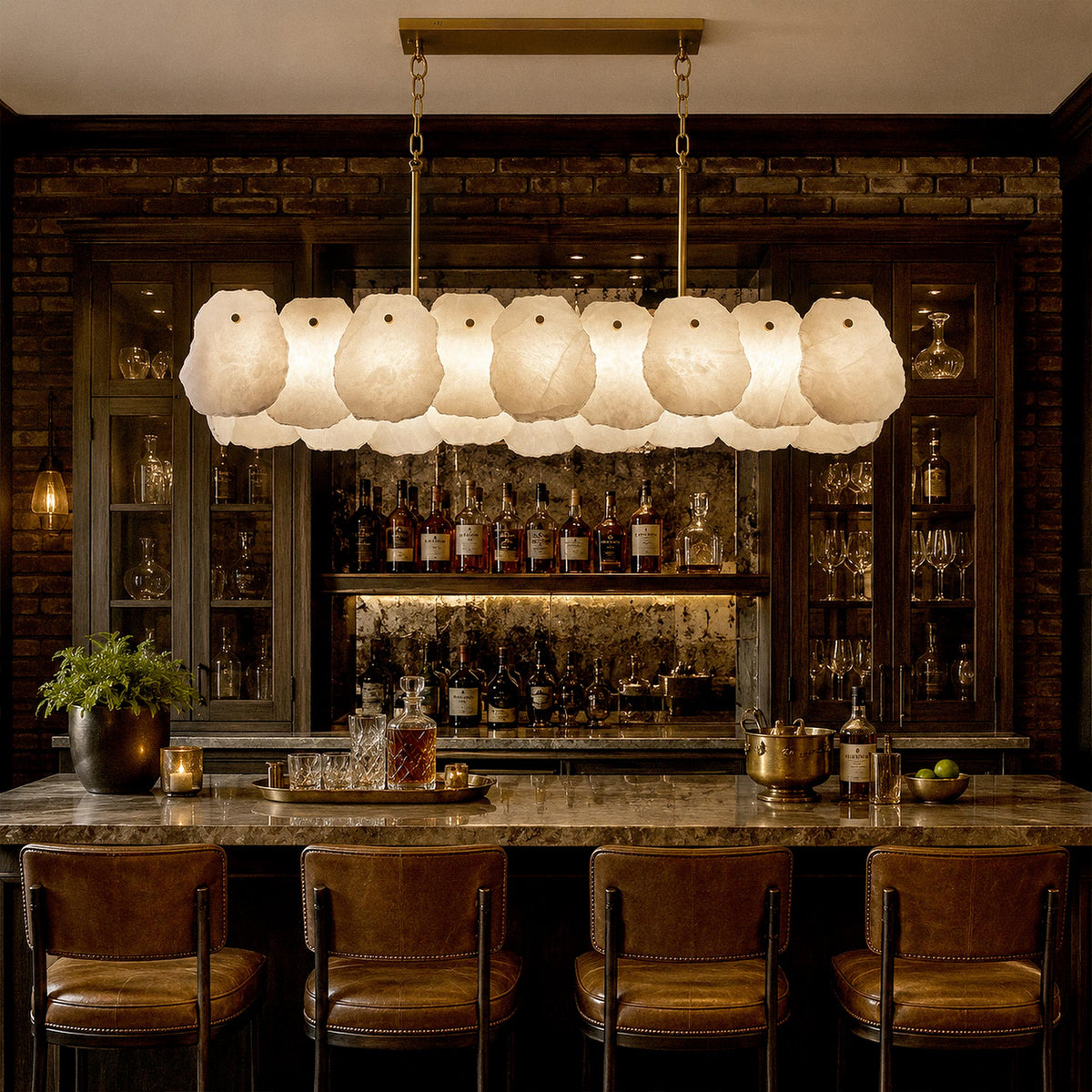 Spanish alabaster bar pendant light hanging above marble home bar counter with leather stools