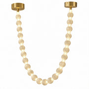 Front view of glowing Spanish alabaster sphere beaded garland pendant light with brass bases isolated on white background
