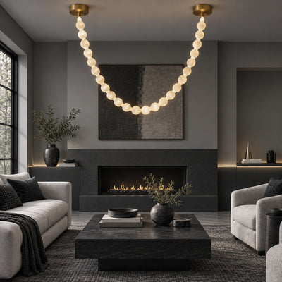 Sculptural Spanish alabaster sphere garland pendant light hanging in a dark tone modern living room above coffee table