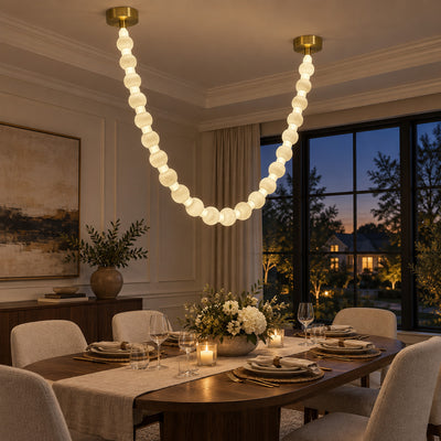 Illuminated Spanish alabaster sphere garland pendant light hanging gracefully above a modern wooden dining table at twilight