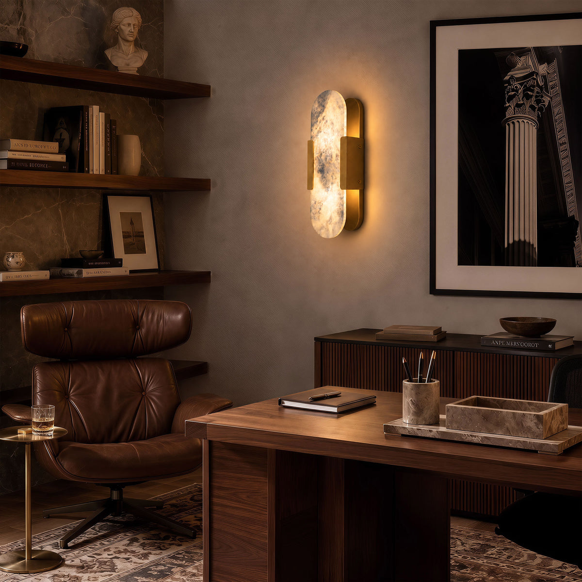 Warmly glowing oval Spanish alabaster wall light installed on grey wall beside dark wood desk in modern study
